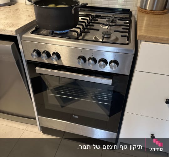 כיריים גז עם סיר שחור על להבה כחולה